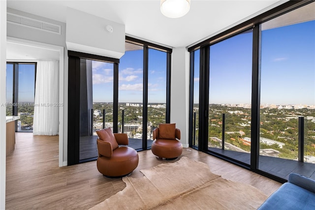 sitting room featuring light wood-type flooring and expansive windows