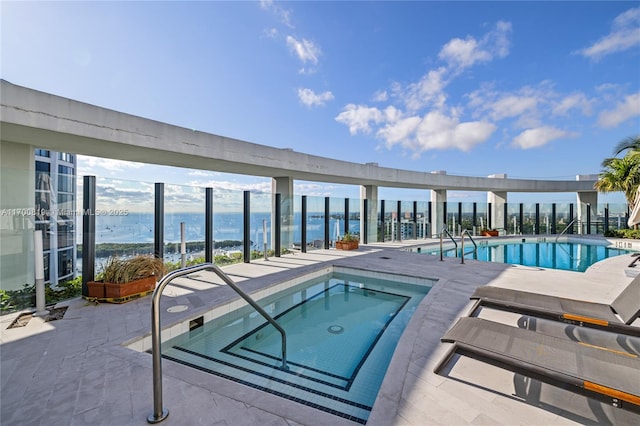 view of pool with a community hot tub and a water view