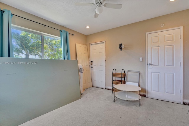 living area featuring ceiling fan and light colored carpet