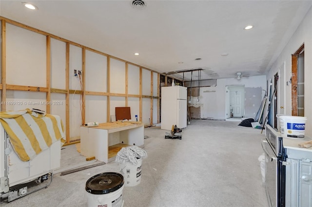 basement featuring white refrigerator and ceiling fan