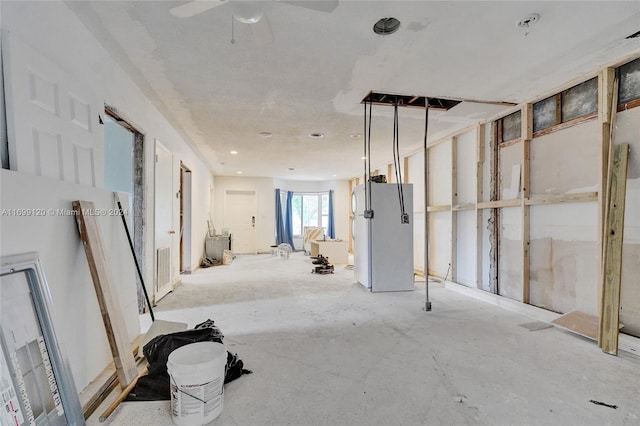 basement featuring ceiling fan and white fridge