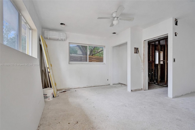 spare room featuring an AC wall unit and ceiling fan