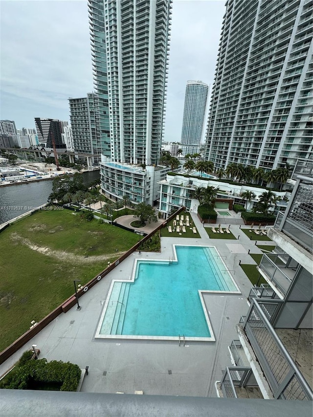 view of pool with a patio and a water view