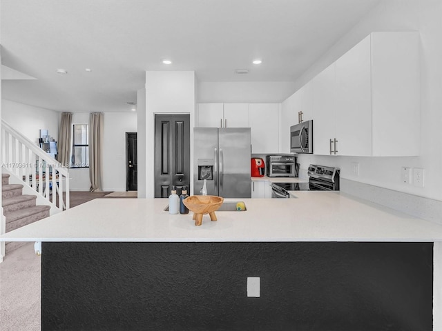 kitchen with kitchen peninsula, white cabinetry, light carpet, and appliances with stainless steel finishes