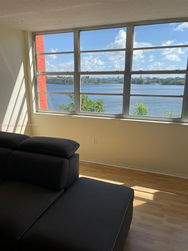 living area with a water view and hardwood / wood-style floors