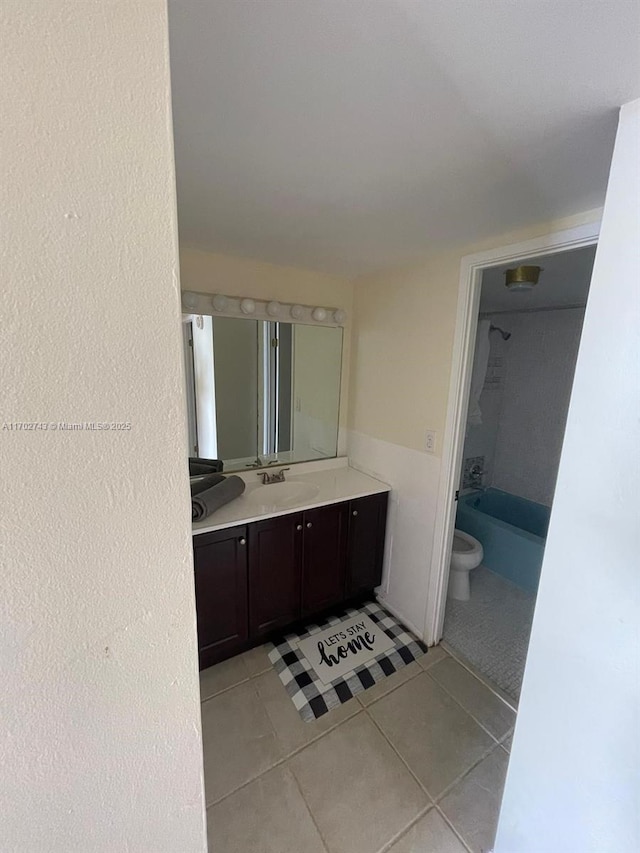 full bathroom with tile patterned flooring, vanity,  shower combination, and toilet