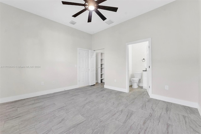 unfurnished bedroom with ensuite bath, ceiling fan, and a closet