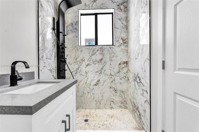 bathroom featuring a tile shower and vanity