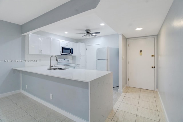 kitchen featuring white appliances, sink, kitchen peninsula, ceiling fan, and white cabinetry