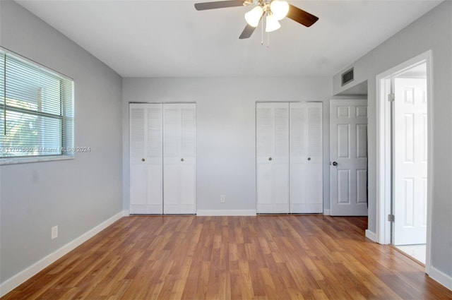 2251 NW 48th Ter Unit 208, Lauderhill, FL 33313 - unfurnished bedroom with multiple closets, wood finished floors, and baseboards
