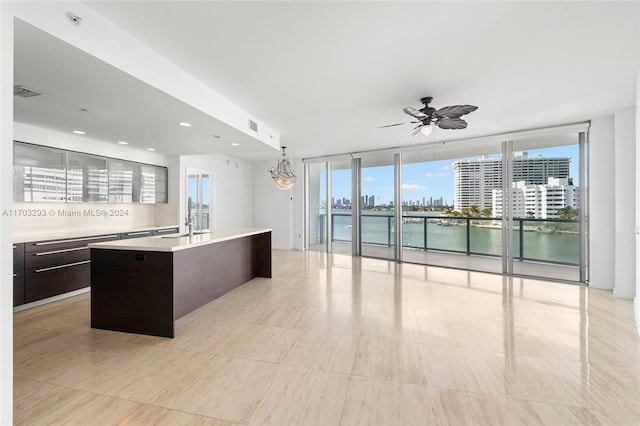 1470 16th St Unit 501, Miami Beach, FL 33139 - kitchen featuring light countertops, modern cabinets, an island with sink, ceiling fan, and floor to ceiling windows