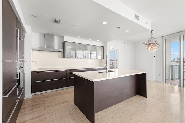 1470 16th St Unit 501, Miami Beach, FL 33139 - kitchen featuring wall chimney exhaust hood, modern cabinets, light countertops, dark brown cabinets, and a center island with sink