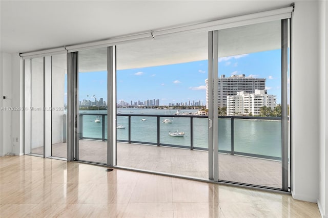 interior space with a wall of windows, plenty of natural light, and a water view