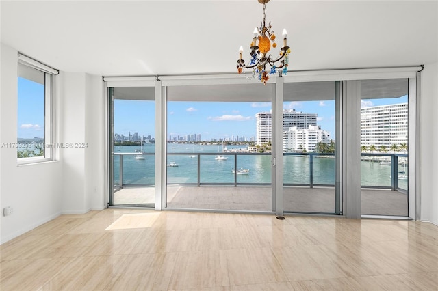 1470 16th St Unit 501, Miami Beach, FL 33139 - empty room featuring expansive windows, a chandelier, a skyline view, and a water view