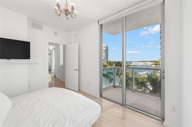 bedroom featuring expansive windows, a water view, access to outside, and an inviting chandelier