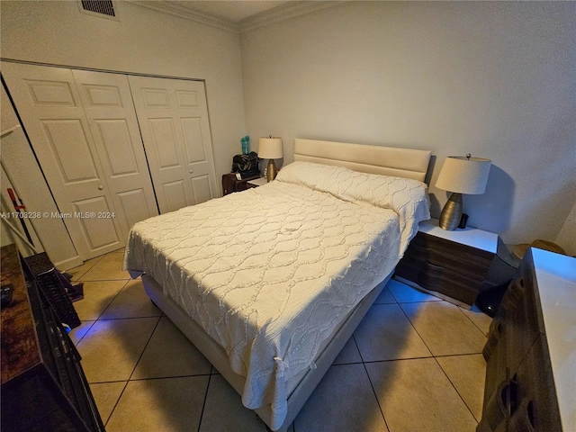 tiled bedroom featuring crown molding and a closet