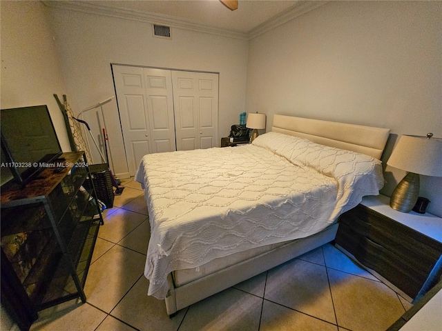 tiled bedroom with a closet, crown molding, and ceiling fan