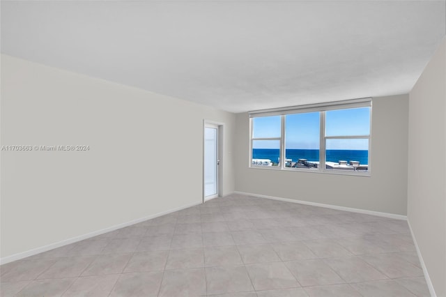 tiled empty room featuring a water view