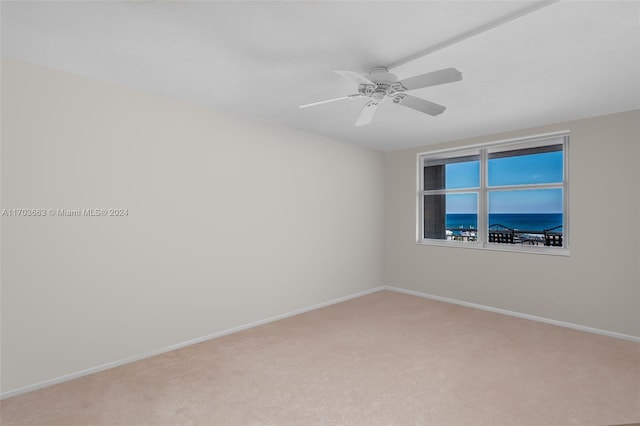 carpeted spare room with ceiling fan