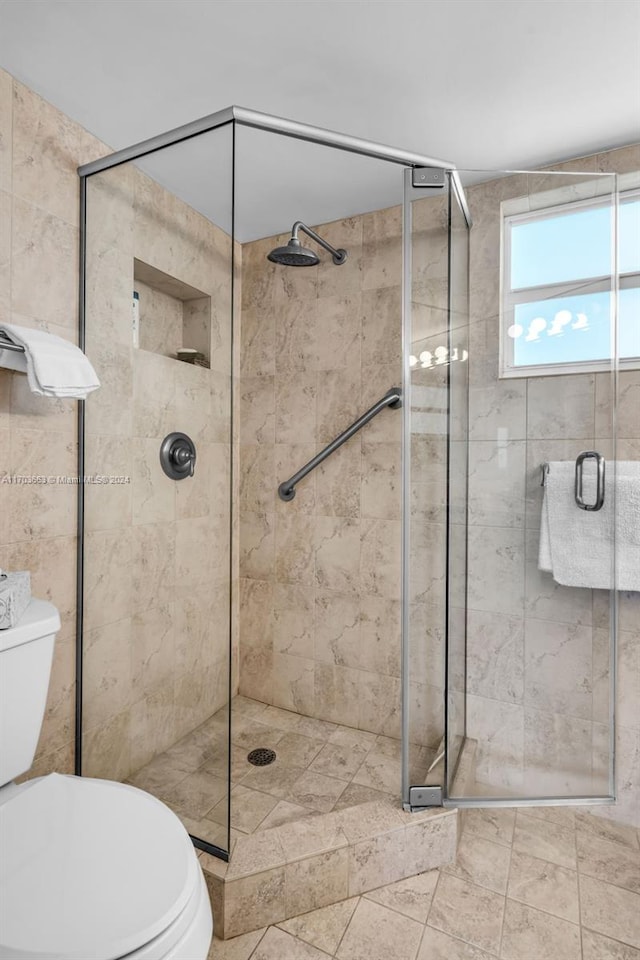 bathroom featuring tile patterned floors, toilet, and walk in shower