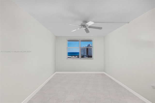 tiled spare room with ceiling fan