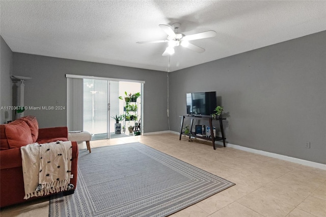 tiled living room featuring ceiling fan and a textured ceiling