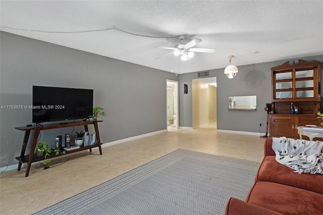 living room featuring a textured ceiling and ceiling fan