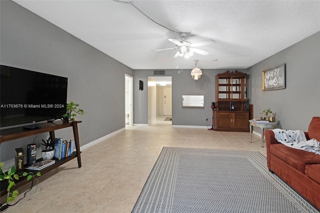 tiled living room featuring a textured ceiling and ceiling fan