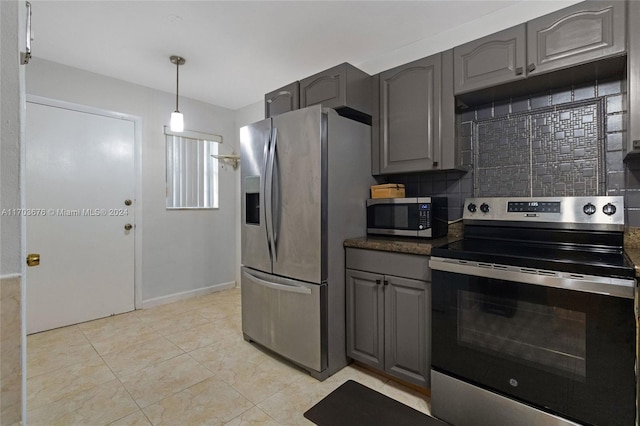 kitchen featuring gray cabinets, decorative backsplash, decorative light fixtures, and appliances with stainless steel finishes