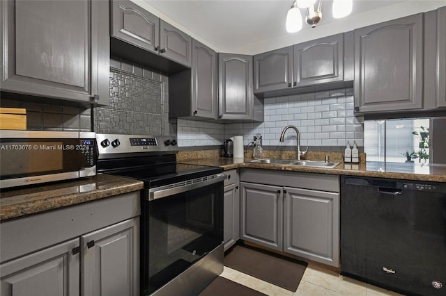 kitchen with sink, tasteful backsplash, gray cabinets, light tile patterned floors, and appliances with stainless steel finishes