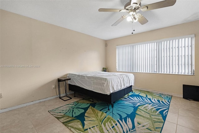 tiled bedroom featuring a textured ceiling and ceiling fan