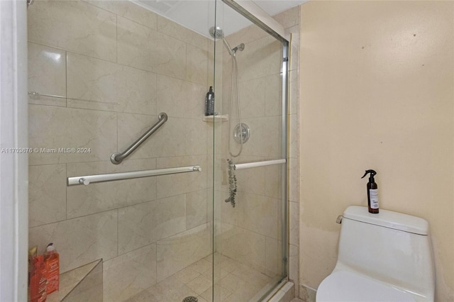 bathroom with toilet and a shower with door