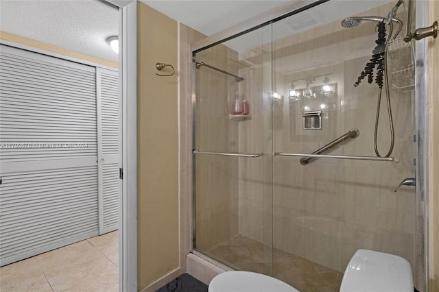 bathroom featuring tile patterned flooring, a shower with door, and toilet