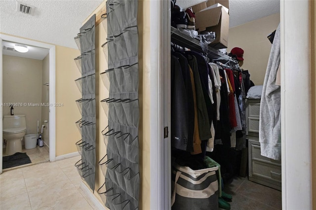 walk in closet with light tile patterned floors