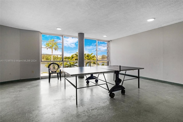 recreation room featuring a wall of windows and a textured ceiling