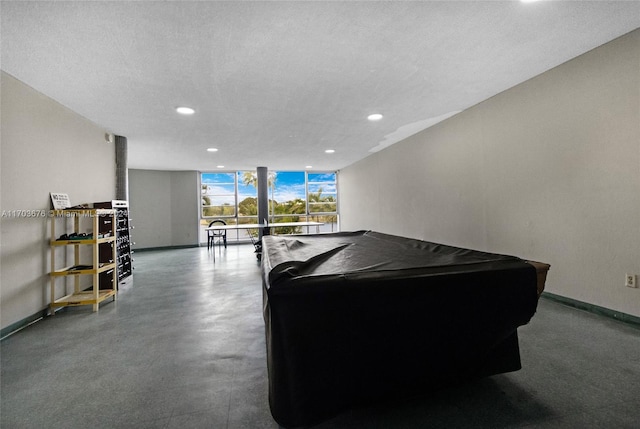 recreation room featuring a textured ceiling, a wall of windows, and pool table