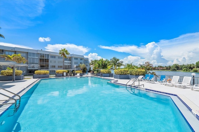 view of pool with a water view and a patio area