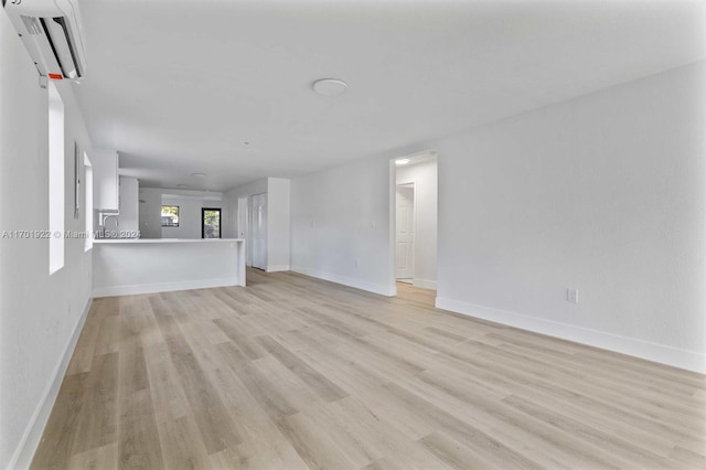 unfurnished living room with light hardwood / wood-style flooring and sink