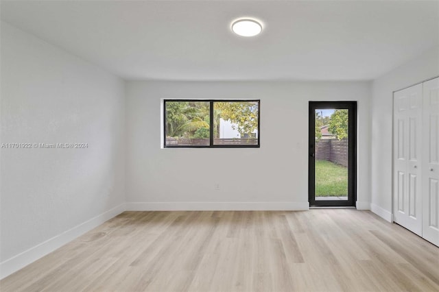 empty room with a healthy amount of sunlight and light hardwood / wood-style flooring