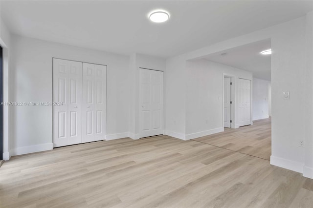 interior space featuring two closets and light hardwood / wood-style floors