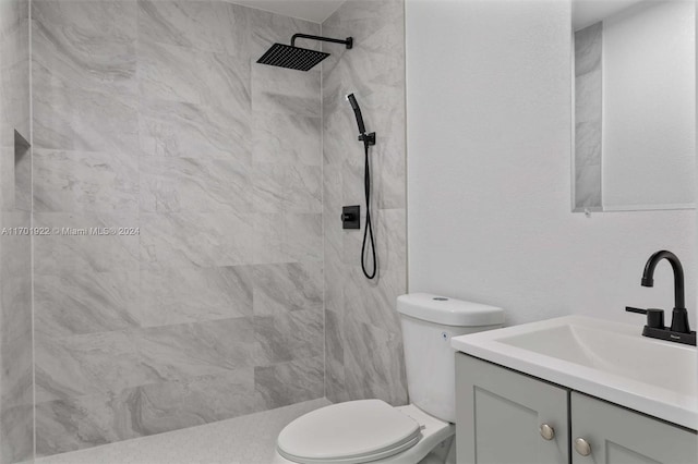 bathroom featuring vanity, toilet, and tiled shower