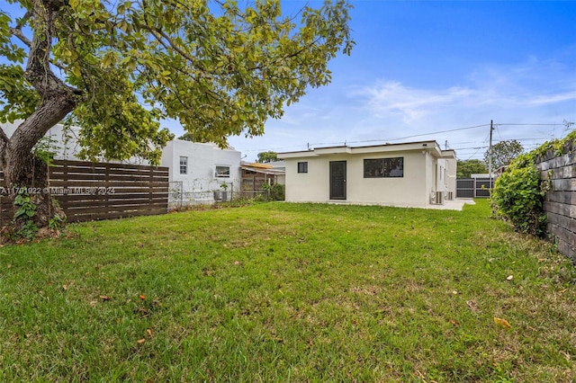 rear view of property featuring a lawn