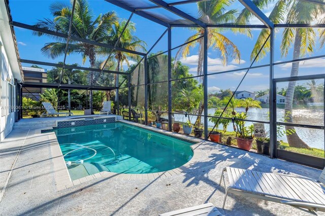 pool at dusk with a water view and a lanai