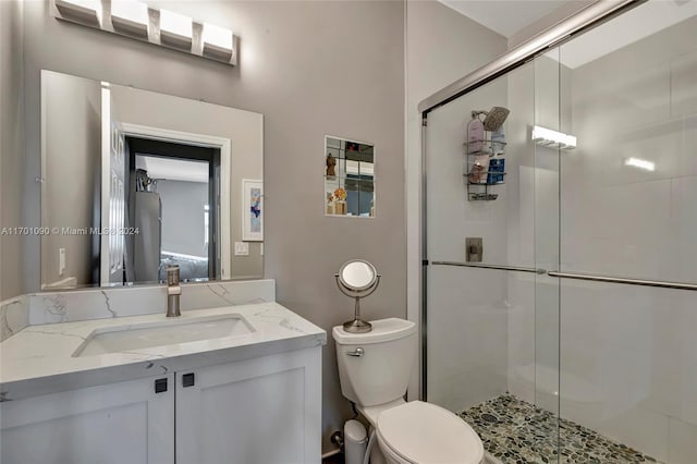 bathroom featuring an enclosed shower, vanity, and toilet