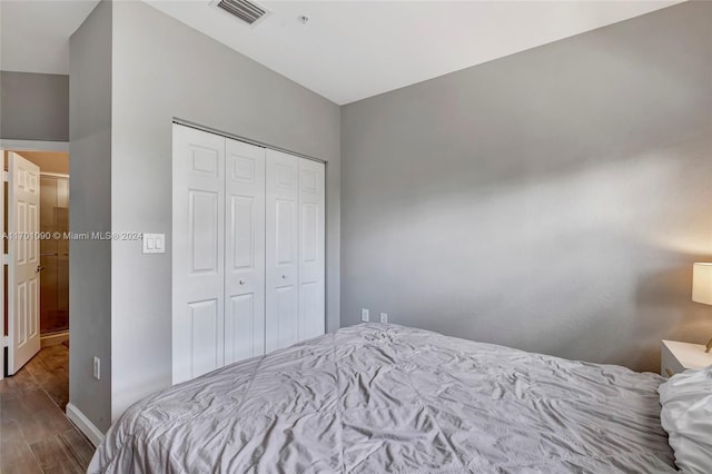 bedroom featuring hardwood / wood-style floors and a closet