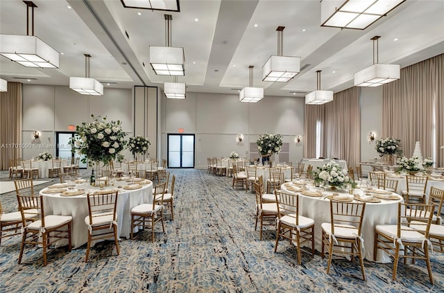 dining space with carpet floors and a towering ceiling