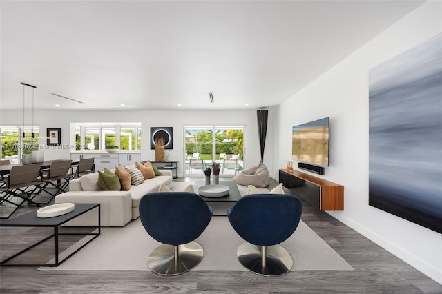 living room with a wealth of natural light and dark wood-type flooring