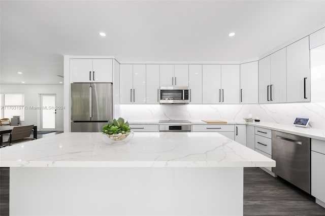 kitchen featuring light stone countertops, white cabinets, dark wood-type flooring, and appliances with stainless steel finishes