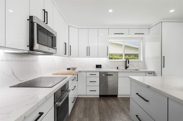 kitchen with white cabinetry, sink, stainless steel appliances, tasteful backsplash, and dark hardwood / wood-style floors