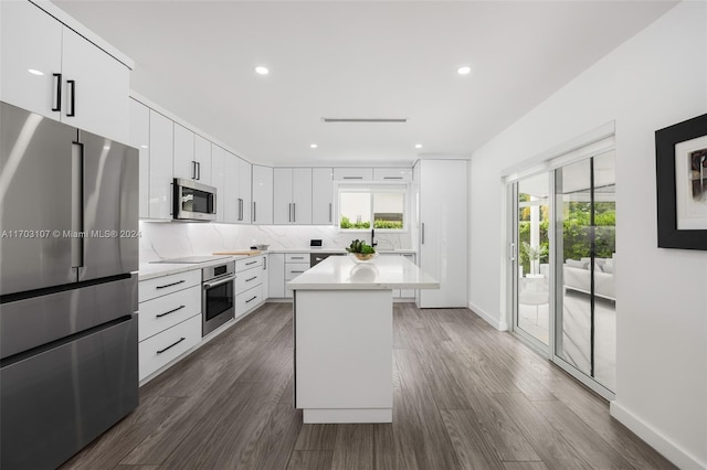 kitchen featuring white cabinets, a center island, dark hardwood / wood-style flooring, and appliances with stainless steel finishes